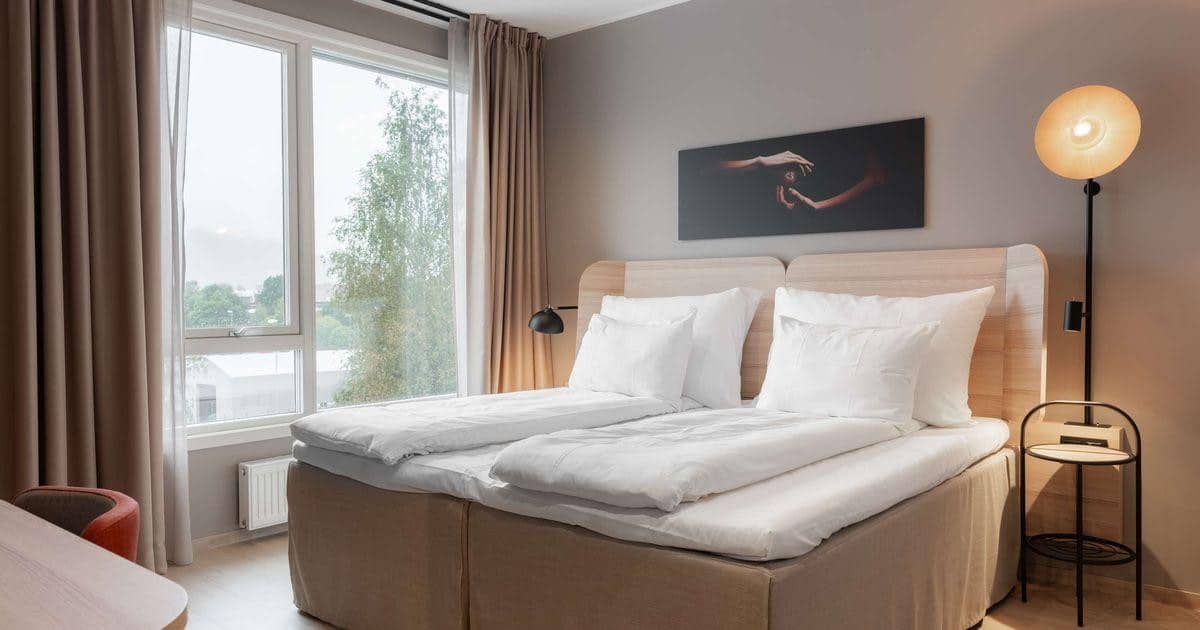 Moderne hotellrom med teppegulv og møbler